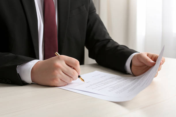 istock Notary signing document at wooden table indoors, closeup 1728651609