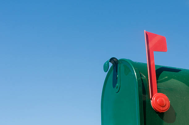 Outgoing mail in rural mailbox with flag in upright position Mailbox with flag up against blue sky. blue mailbox stock pictures, royalty-free photos & images