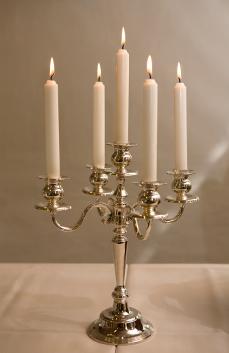 A five-branched candlestick placed at a table
