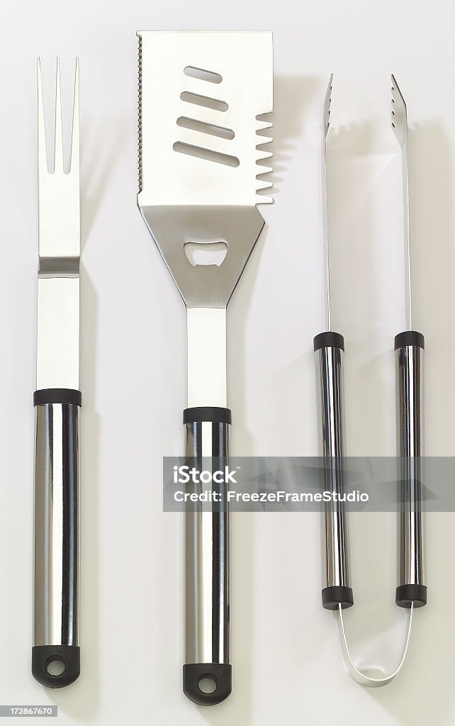 Chromed, stainless BBQ tool set; spatula, fork & tongs Modern chrome BBQ tool set on white background Celebration Event Stock Photo