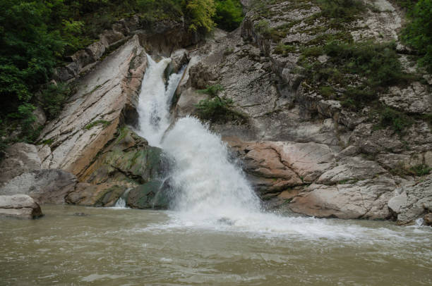 istock The waterfall is small, the water descends between the rocks from the mountain 1728677411