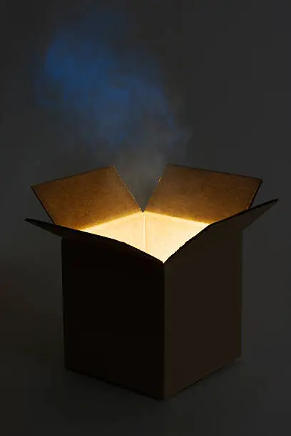 Subject: An opened cardboard box package with glowing light and magic smoke rising from the box.