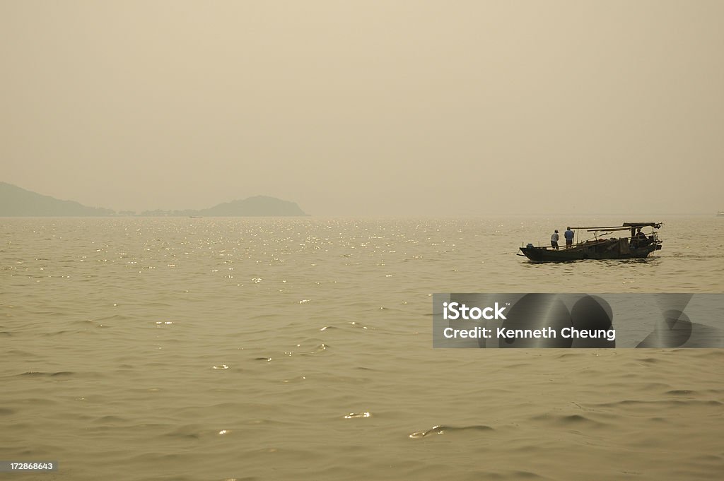 Bateau de pêche au coucher du soleil sur le lac Tai - Photo de Asie libre de droits