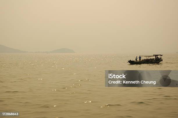 Photo libre de droit de Bateau De Pêche Au Coucher Du Soleil Sur Le Lac Tai banque d'images et plus d'images libres de droit de Asie