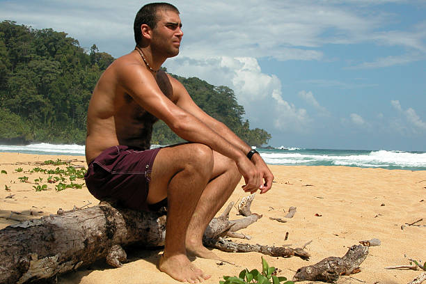 istock Man Sitting on Tree Truck at Tropical Beach Paradis 172869571