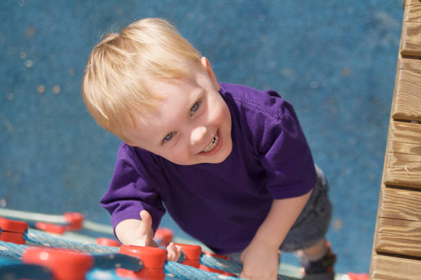 istock Boy Looks Up From Climbing a Playground Rope Ladder 172870132
