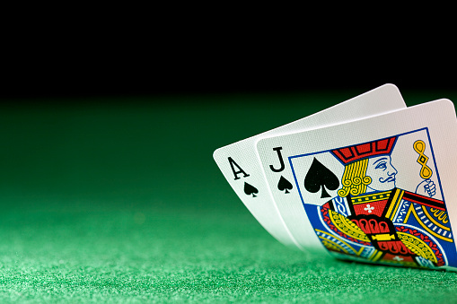 Black jack on a poker table against a black background and selective focus.