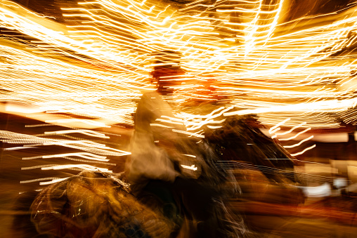 Long exposure image of an Adult woman enjoying a ride on a carousel at night in Italy