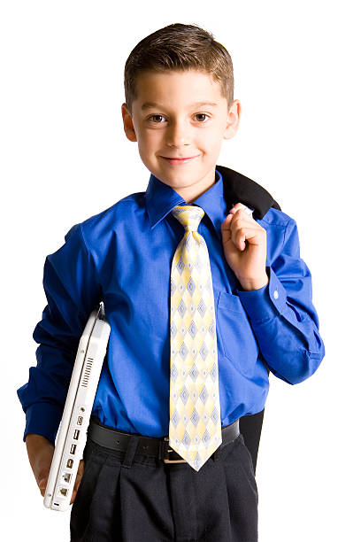 Portrait of a smiling young boy with missing teeth, wearing a gray t-shirt and holding a black tie, conveying a sense of playful confidence and childhood charm