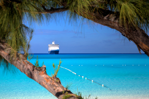 A ship waits on the horizon on a beautiful beach in the Caribbean.