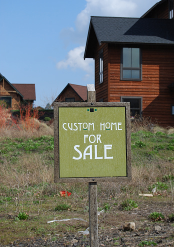 Custom home for sale with nice sign & blue sky.  Focus on the sign.