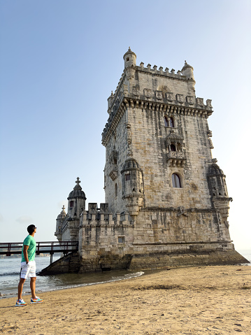 Young man looking at the Belém Tower
