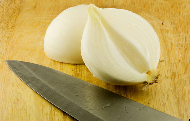 istock Onion halved on chopping board with Knife 172874469