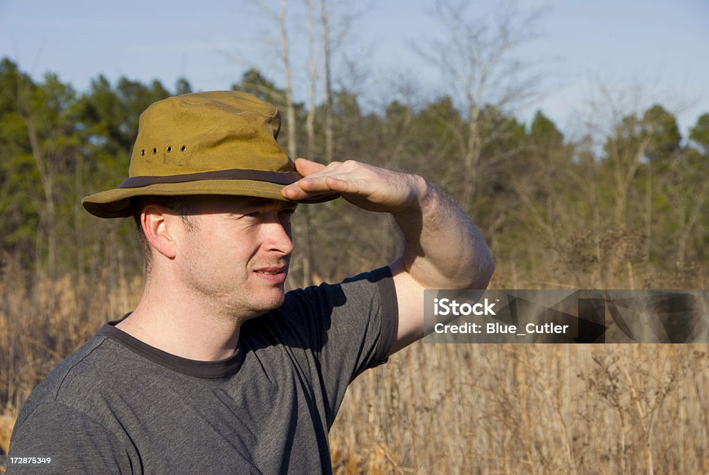 Exploring A man shielding his eyes. Shielding Eyes Stock Photo