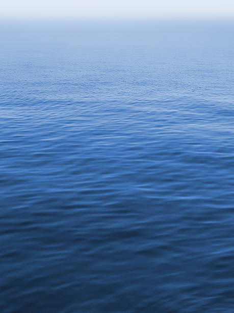 silent misty sea, blue water surface with small waves stock photo