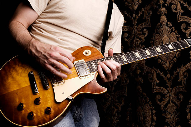 istock A closeup of a man from the shoulders down playing guitar 172877173