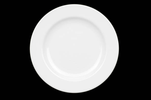 Top down view of empty white dinner plate on black surface stock photo