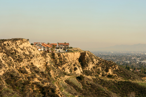Cliffside homes in Porter Ranch area of the largest suburbs in USA, Northridge, California down below, 'the valley' , San Fernando Valley, part of the city/county of Los Angeles, CA; Santa Monica Mtns in smoggy distance,smog,pollution,home,cliff,hill,scenic
