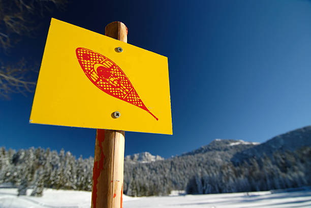 A yellow sign indicating a snow shoeing path