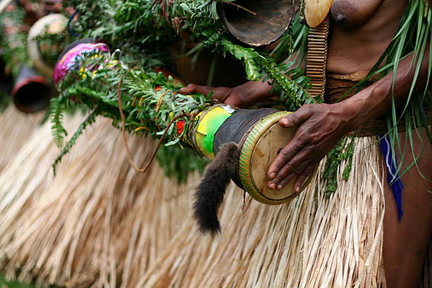 Tribal Drum Woman beating a hand-made drum as part of a tribal ceremony. Papua New Guinea. Papua New Guinea stock pictures, royalty-free photos & images