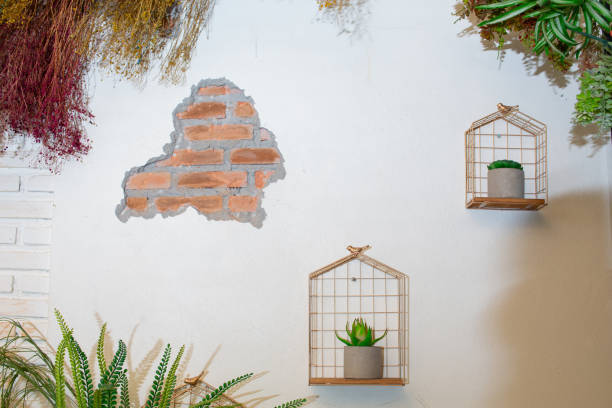 istock Bird cage decorated with flowers installed on the white wall. 1728779481