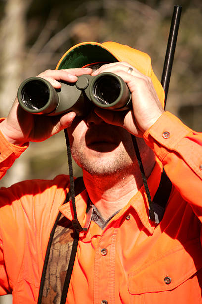 istock Man in hunting gear looking through binoculars  172878920