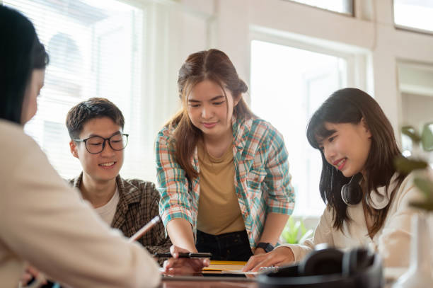 istock A beautiful Asian female student is helping her friends with math homework. 1728818960
