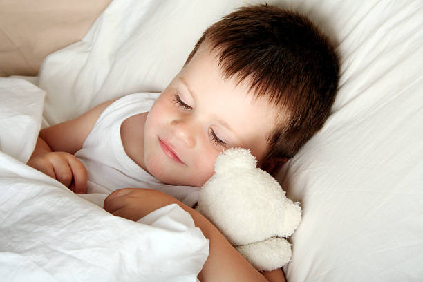 happy sleeping child with teddybear stock photo