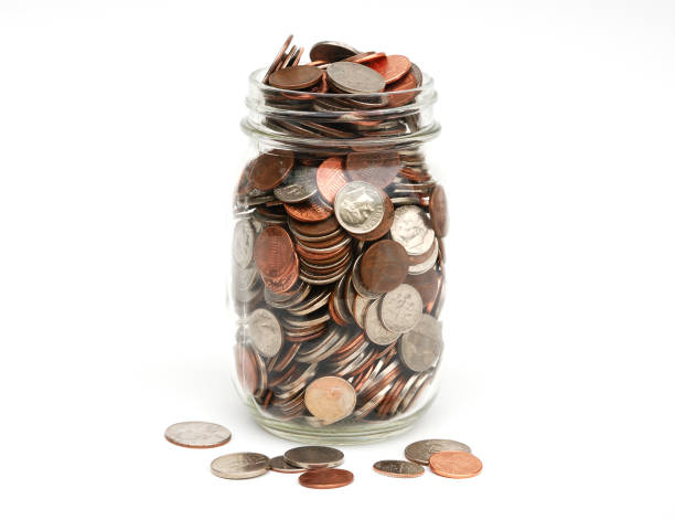 pote de monedas y abundantes completo - jar coin currency glass fotografías e imágenes de stock