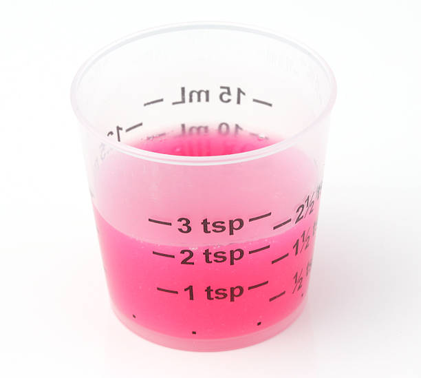 Medicine Dosing Cup Cold and cough medicine dosing cup with 2 teaspoons of syrup. tsp stock pictures, royalty-free photos & images