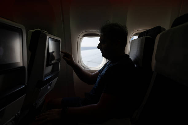 istock Indian man using inflight entertainment on a flight to Paris 1728897849