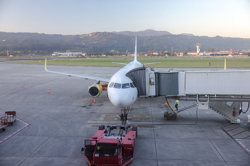 View from airport departure area of the passenger boarding bridge on airport tarmac awaiting arrival of airplane.