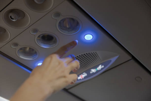 Hand pressing the Flight attendant call button in a commercial airplane