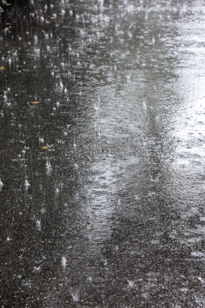 istock city pavement during heavy rain with raindrops splashes on water surface 1728918072