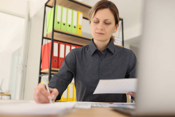 istock Focused woman writes notes while reading investigation paper 1728919194