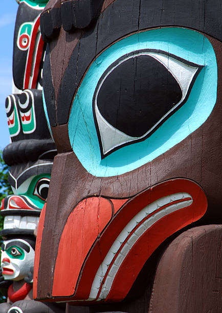 Pacific Northwest Close up of a totem pole in Stanley Park in Vancouver, BC. Totem poles are monumental sculptures carved from trees, usually cedar, by various Indigenous people along the Pacific northwest coast of North America. pacific northwest totem poles stock pictures, royalty-free photos & images