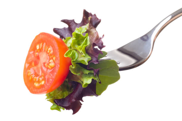 Salad on a fork "Close-up of salad on a fork, isolated on a white background." green leaf lettuce stock pictures, royalty-free photos & images