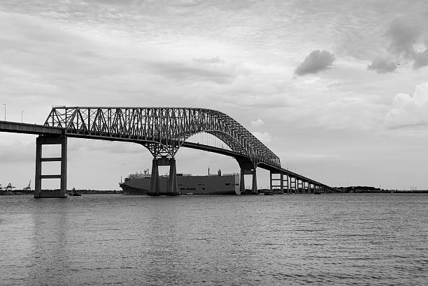 A ship passes under the Francis Scott Key Bridge on the Patapsco River in Baltimore, Maryland. It is close to where Francis Scott Key witnessed the bombardment of Fort McHenry where he was inspired to write the Star Spangled Banner, the US national anthem.