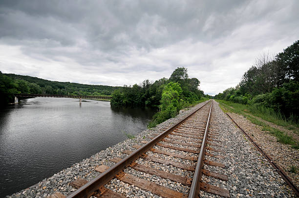 A railroad track with stormy skies in the background.