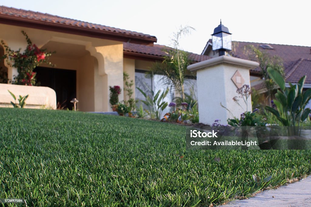 House with Synthetic Lawn Tract home featuring synthetic lawn (astro turf or fake grass if you must).  Focus is on the grass, fake though it might be. Artificial Stock Photo