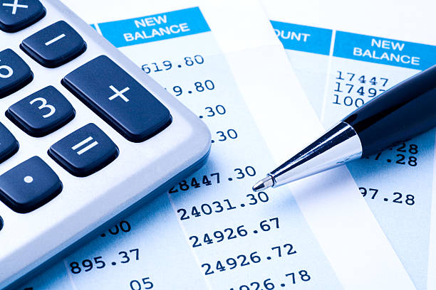 Balancing the Accounts "Close-up of a calculator, pen, and financial statement. Blue-toned image." bank account stock pictures, royalty-free photos & images