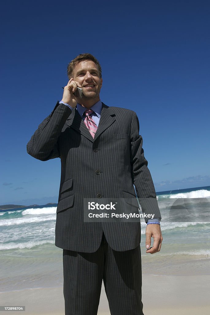 Улыбающийся бизнесмен переговоры на пляже - Стоковые фото Беспроводная технология роялти-фри