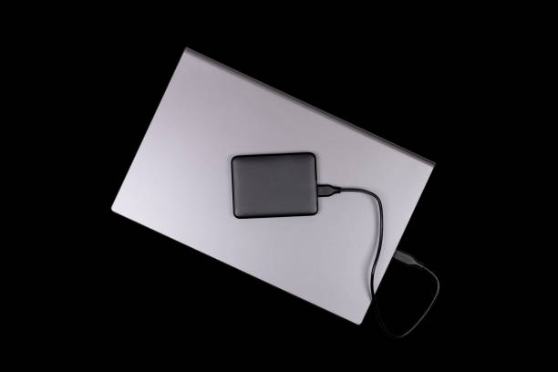istock laptop and hard drive isolated on black background top view 1728991048