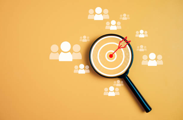 istock Customer group icons in a magnifying glass placed on a yellow background represent the selection of business goals, target customers. Marketing plans and strategies, customer-centric strategies. 1728992986