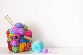 Cozy homely atmosphere. Female hobby knitting and Crochet. Yarn multicolor in a basket. Skeins and balls. copy space