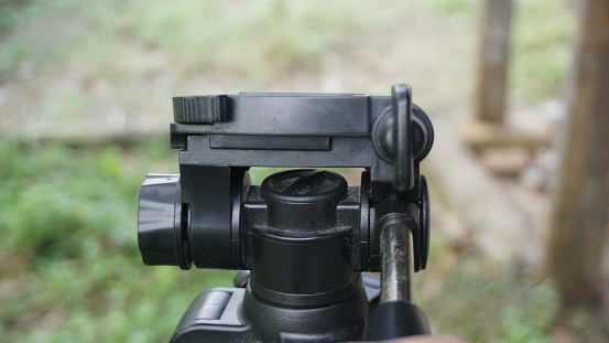 Close-up of a tripod on a blurred background of green grass