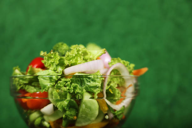 Big bowl of vegetable salad over green background, Horizontal in size