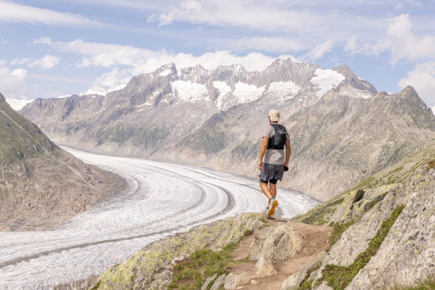 istock Trail runner pauses on mountain pass, looking at view 1729018904