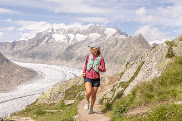 istock Female trail runner ascends alpine path in Swiss mountain landscape 1729018911