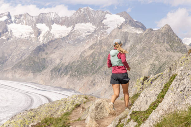istock Female trail runner ascends alpine path in Swiss mountain landscape 1729019437
